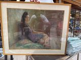 a man holding a picture of a woman sitting on the ground