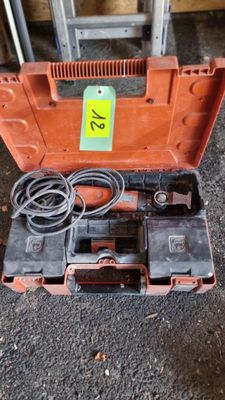 une boîte à outils orange contenant des outils, posée par terre