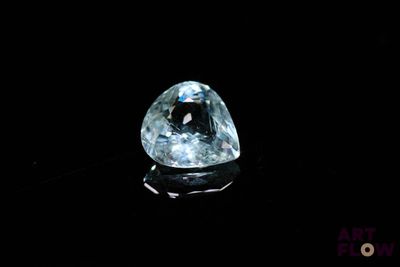 a close up of a blue diamond on a black surface