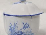 a blue and white bowl with a lid on a white surface