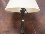 une lampe posée sur une table, avec un abat-jour blanc
