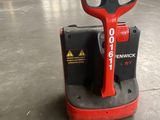 un chariot élévateur rouge et noir garé dans un entrepôt
