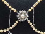 pearl necklace with a flower and initial charm on a chain