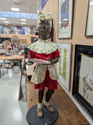 a statue of a woman holding a tray in a room
