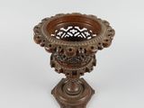 a small wooden vase with a decorative design on it