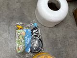 two rolls of toilet paper, a cup of coffee, and some other items on the floor