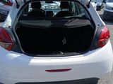the back of a white car with its trunk open in a parking lot