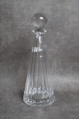 flacon de parfum en verre transparent muni d'un bouchon en verre, sur fond gris