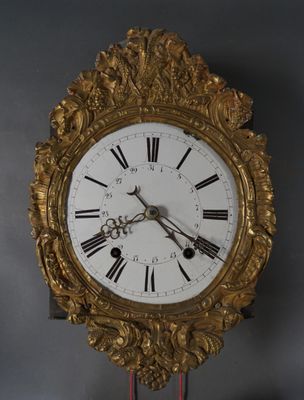 une horloge en or dont le cadran est orné de chiffres romains