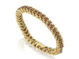 une bague en or jaune sertie de saphirs roses sur fond blanc