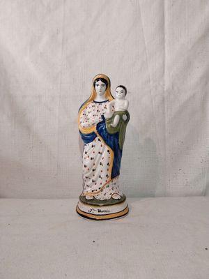 une figurine représentant une femme tenant un enfant dans ses bras