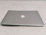 a silver apple laptop sitting on a white surface