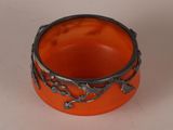an orange bowl with a star design on it sitting on a white surface