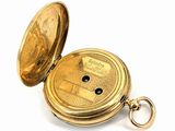 a gold pocket watch with a keychain on a white surface