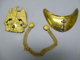two pieces of gold jewelry on a white surface