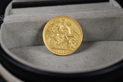 une pièce d'or posée dans un écrin sur une table