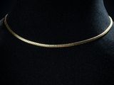 un collier ras-du-cou en or sur un mannequin, un mannequin, un mannequin, un mannequin, un mannequin, un mannequin, un mannequin, un mannequin, un manne