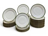 six plates with green rims are stacked on top of each other