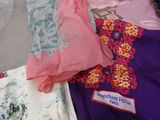 many different types of clothing on a bed