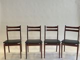 a set of four danish dining chairs with black leather seats