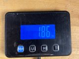 a digital clock that is on the table next to a cell phone