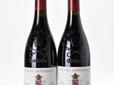 two bottles of red wine sitting next to each other on a white surface