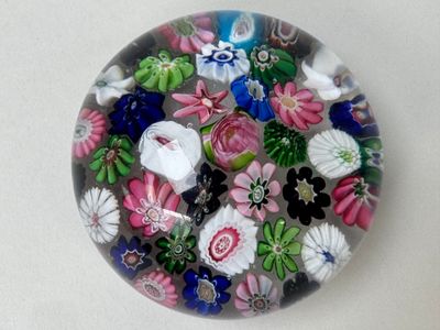 une photo d'un presse-papier en verre orné de fleurs