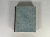 un livre bleu posé sur une table blanche