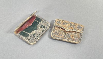 two pieces of jewelry that are sitting on a table