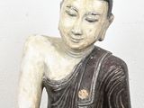 a small statue of a person sitting on a stool