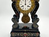 une horloge posée sur une table, à côté d'une paire de ciseaux