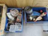 two blue bins filled with assorted items on the floor
