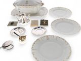 a white table setting with silver and white plates and silverware