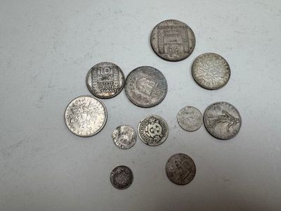 several silver coins are arranged on a white surface