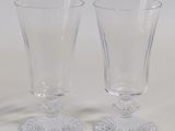 two empty wine glasses sitting next to each other on a table