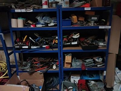 une étagère bleue sur laquelle sont disposés de nombreux outils de toutes sortes