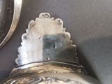 a silver bell hanging on a wall next to a mirror