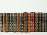 plusieurs vieux livres sont alignés sur une surface blanche