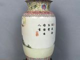 a white vase with asian writing on it sitting on a wooden table