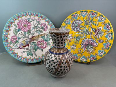 trois vases et une assiette posés sur une table