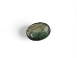 a close up of a green stone on a white surface