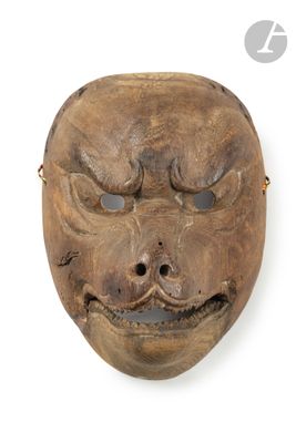 un vieux masque en bois sur fond blanc, avec un petit trou au milieu