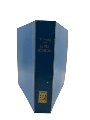an old blue book sitting on top of a white surface