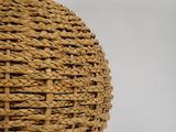 a wicker lamp with a white shade on a table