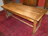 a wooden table with a red rug on the floor