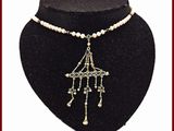 collier de perles avec un pendentif en perles et un pendentif en perles, présenté sur un mannequin noir