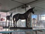 trois statues de chevaux exposées dans une vitrine
