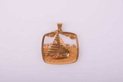 une image représentant un pendentif en or orné d'un voilier