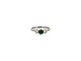 Gros plan sur une bague ornée d'une pierre verte