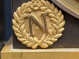 a gold clock with a wreath on top of it